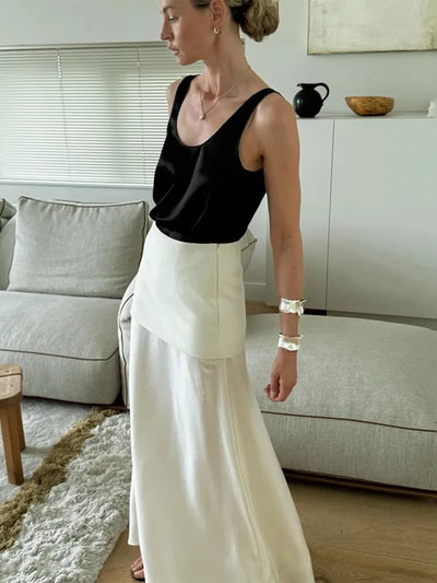 Side view of woman in white double-layer maxi skirt with silver cuff bracelet in bright interior