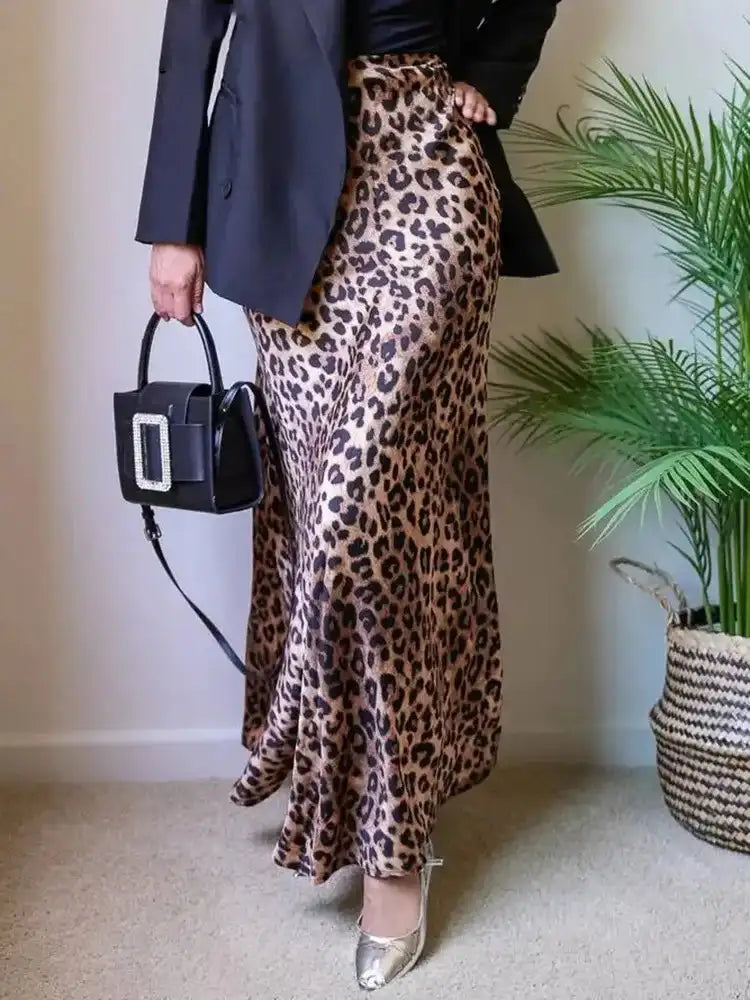 Front view of leopard-print maxi satin skirt worn with black blazer and structured bag
