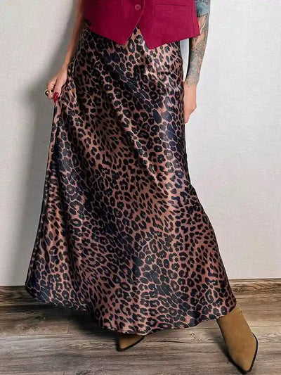 Front view of leopard maxi skirt styled with cropped burgundy vest and ankle boots