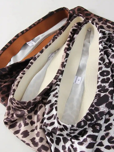 Flat lay detail of wide elasticated waistband on three leopard-print satin skirts