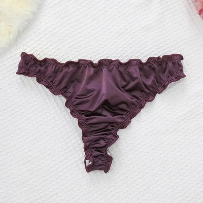 Single burgundy satin thong with ruffled waistband and leg openings on white surface