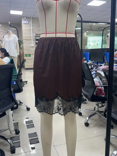 Front view of dark brown mini skirt with black lace trim on dress form, elasticated waistband visible