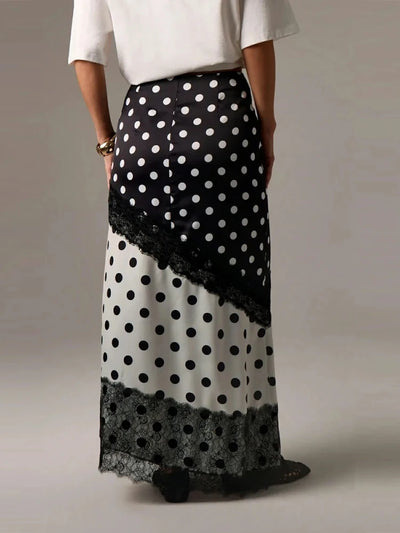 Back view of two-tone polka dot satin maxi skirt showing diagonal lace panel and hem trim