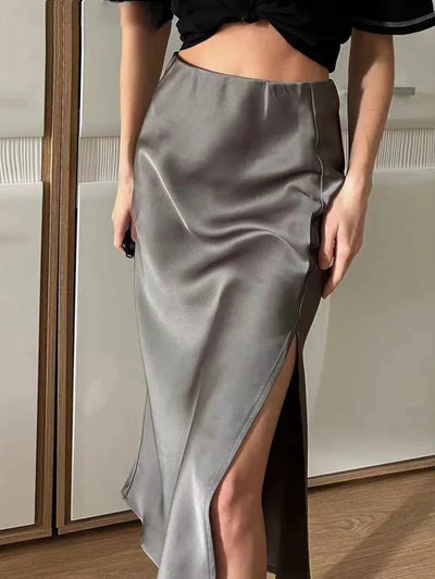 Close-up of gray satin midi skirt with front side slit, paired with black crop top