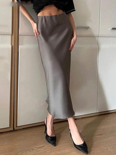 Gray satin midi skirt back view, smooth waistband, paired with black pointed-toe heels