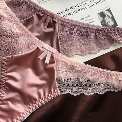 Close-up of two pink and mauve satin thong panties showing bow detail and scalloped lace trim