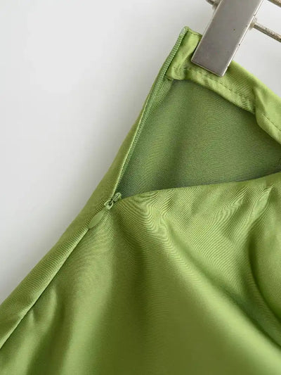 Back zip closure detail of olive green satin mini skirt with lining visible