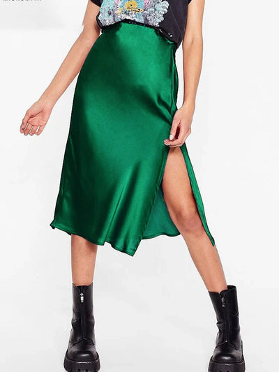 Front view of emerald green high-waist satin midi skirt with side slit and boots