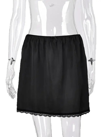 Black satin mini skirt with elastic waist, bow detail, and scalloped lace hem on mannequin