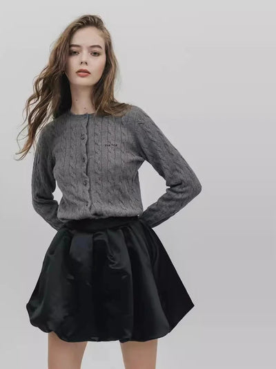 Full-length view of gray button-front cardigan and black satin bubble-hem skirt set