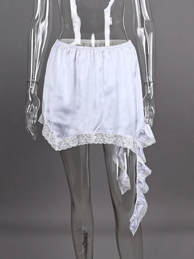 White asymmetric satin mini skirt with floral lace trim and side ruffle displayed on a clear mannequin form, gray background