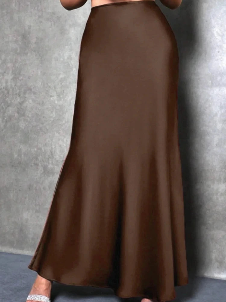 Chocolate brown high-waist flared maxi satin skirt worn with silver strappy heels