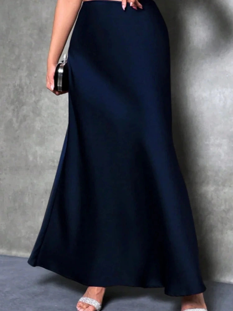 Navy high-waist floor-length satin maxi skirt with flared hem, worn with heeled sandals