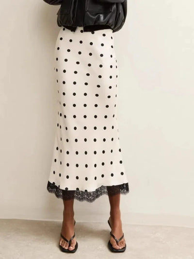Ivory polka dot satin midi skirt with black lace hem, styled with a leather jacket, front view
