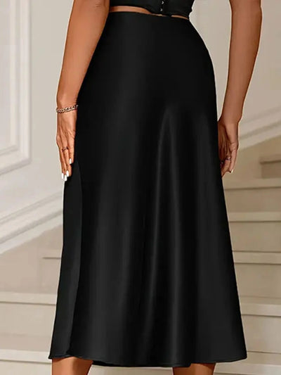 Back view of a black high-waist satin midi skirt with smooth A-line silhouette on a model