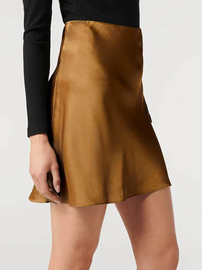 Side view of a golden satin flared mini skirt paired with a black long-sleeve fitted top