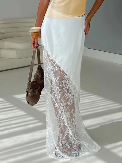 White maxi skirt with satin hip panel and sheer floral lace lower section, side angle, brown leather bag in hand
