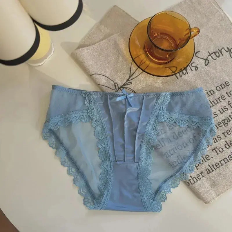 Sky blue satin brief panties with scalloped lace trim and small bow detail, flat lay on linen fabric