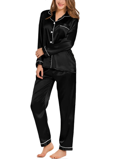 Woman wearing black satin long sleeve button-down pajama set with white contrast piping