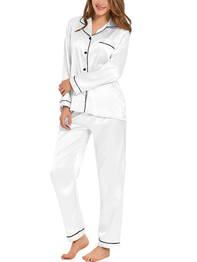 Woman wearing white satin long sleeve button-down pajama set with black contrast piping