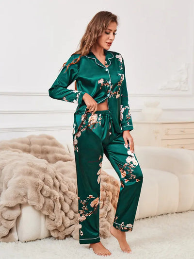 Woman standing showing elasticated waist of green floral satin pajama pants with long-sleeve top