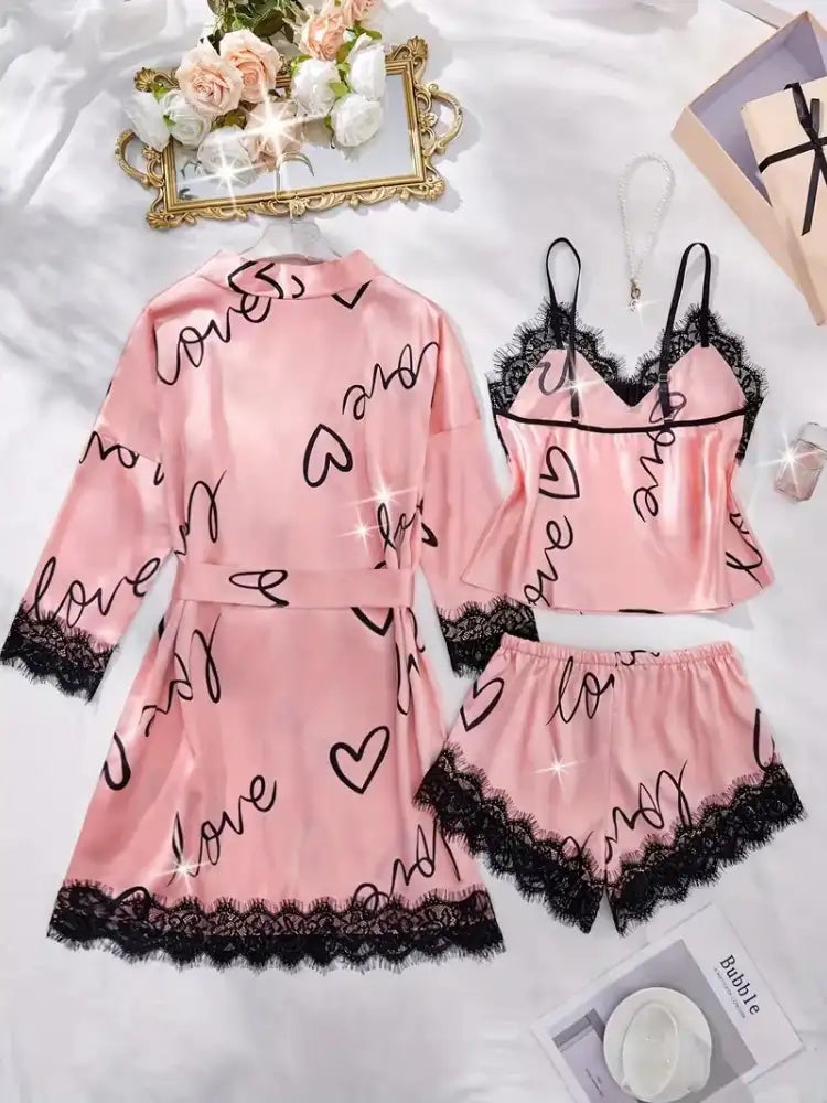 Pink satin 3-piece pajama set with black love print and lace trim flat lay