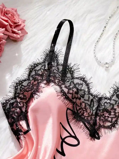 Close-up of black eyelash lace V-neckline on pink satin cami top