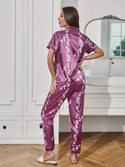Back view of deep purple satin cherry blossom pajama set showing white contrast piping and full-length pants