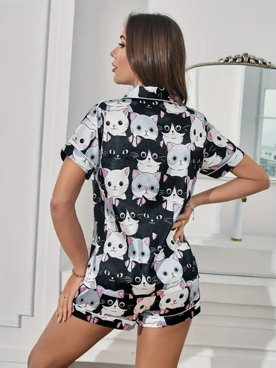 Woman in black cartoon cat print satin pajama set shown from the back, notched collar visible