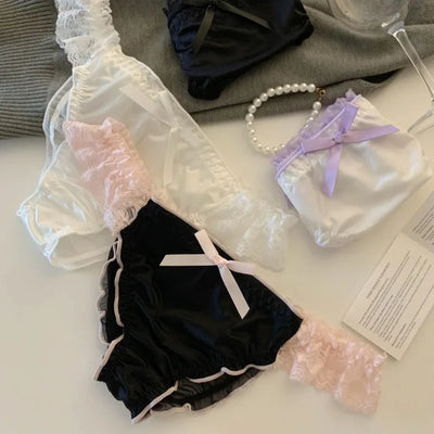 Black white and lavender satin panties with lace trim and ribbon bows flat lay