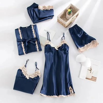 Navy blue satin five-piece pajama set with cream lace trim flat lay on white surface