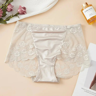 Flat lay of beige satin panties with scalloped floral lace panels and elastic waistband