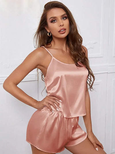 Blush satin spaghetti strap cami and shorts pajama set on a female model