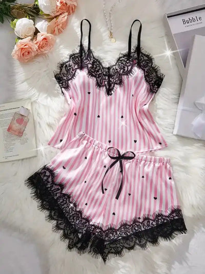 Pink and white striped satin pajama set with black lace trim and heart print, flat lay