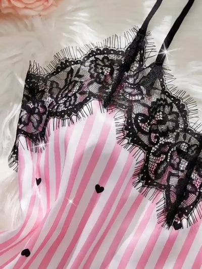 Close-up of black floral lace trim on pink striped satin cami top with heart print