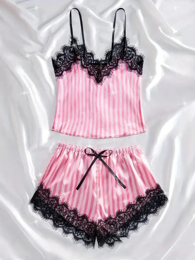 Pink and white striped satin pajama set with black lace trim, flat lay on white satin