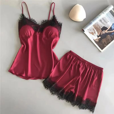 Burgundy satin cami and shorts pajama set with black lace trim flat lay
