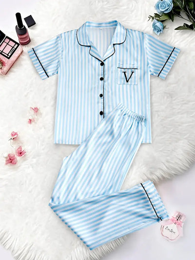 Sky blue and white striped satin pajama set flat lay, front view with V logo chest pocket and black buttons