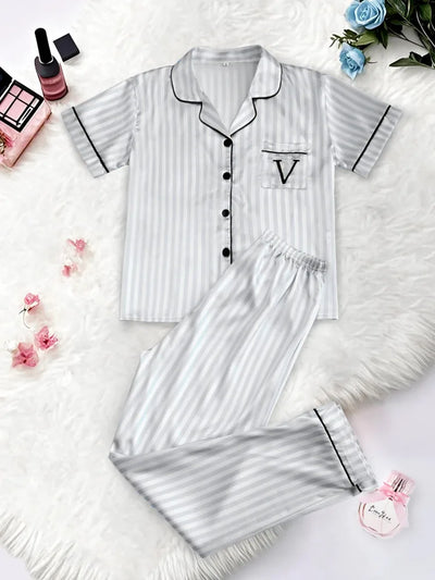 Gray and white striped satin pajama set with V-logo chest pocket and black piping, flat lay front view