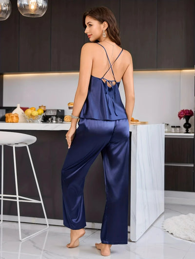 Back view of navy satin cami top showing crossover tie straps and wide-leg pajama pants