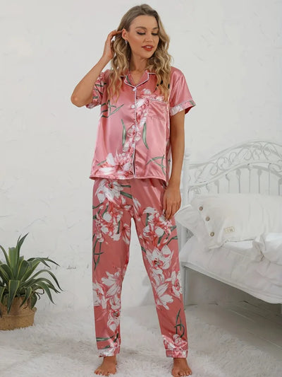 Woman in pink lily-print satin pajama set with hand in hair, relaxed front pose