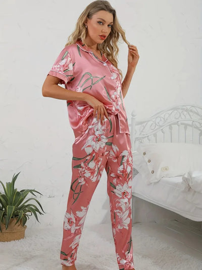 Three-quarter front view of woman in pink floral satin pajama set, hand tucking hair