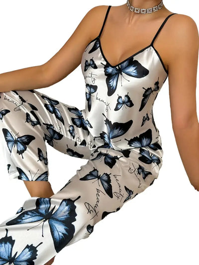 Close-up front view of white butterfly-print satin cami pajama set with script detail