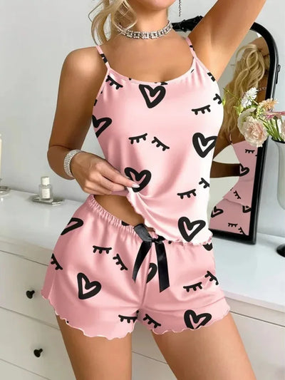 Side view of pink heart print satin pajama set with black ribbon tie on shorts