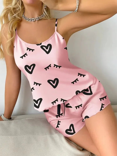 Close angled view of pink satin cami and shorts set with heart graphic print
