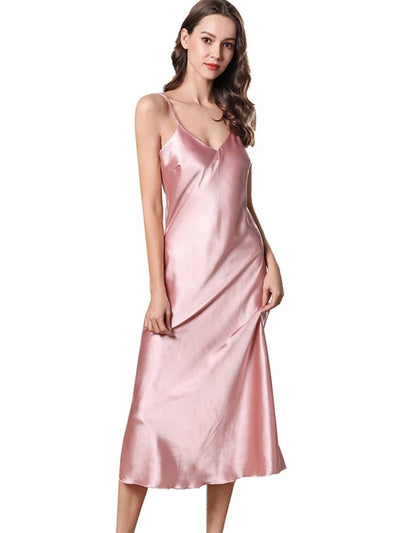 Woman wearing blush pink satin midi nightgown with V-neckline and adjustable straps, front view