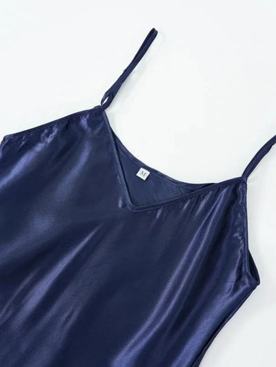 Close-up of navy satin V-neck nightgown neckline with size M label and spaghetti straps