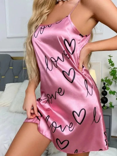 Side view of pink satin slip nightgown with cursive love and heart print, mini hemline, thin adjustable straps