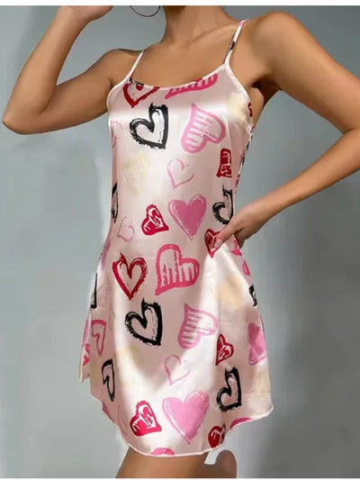 Side view of blush graffiti heart print satin nightgown with curved hem and A-line swing