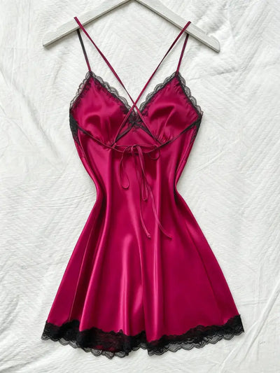 Hot pink crossback satin nightgown on hanger showing ribbon tie and deep V-neckline with black lace